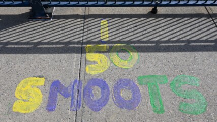Painted letters spelling out '50 SMOOTS' painted on the ground of the Harvard Bridge