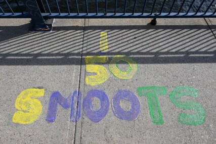 Painted letters spelling out '50 SMOOTS' painted on the ground of the Harvard Bridge