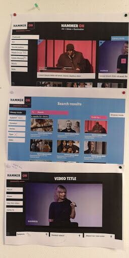 Photograph of pages featuring images of early prototype screens up on the wall in our project room