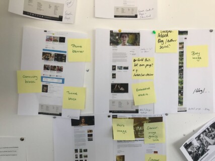 Photograph of post-its on a wall showing research into the old information architecture of the Hammer website